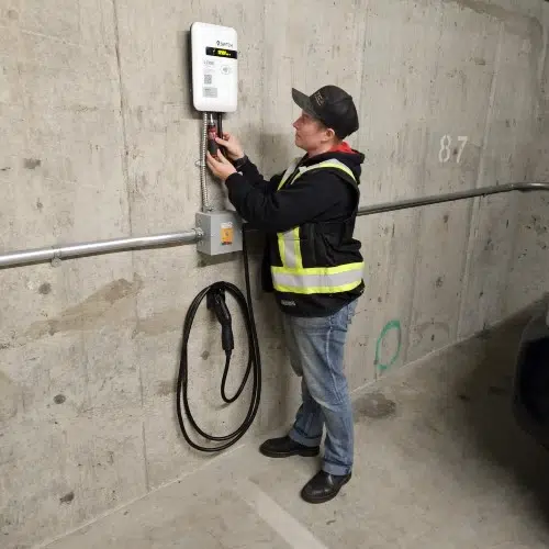 Professional electrician connecting wiring for an EV charging station by TCA Electric