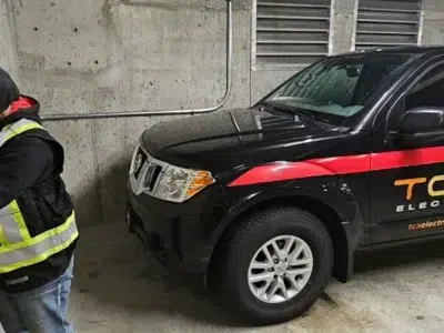 Certified electrician installing an electric vehicle charger in a parking garage by TCA Electric