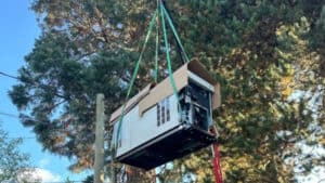 A generator hanging on to a crane in a process of generator installation by TCA Electric in Vancouver