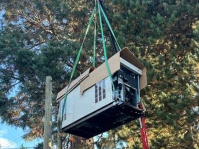 A generator hanging on to a crane in a process of generator installation by TCA Electric in Vancouver