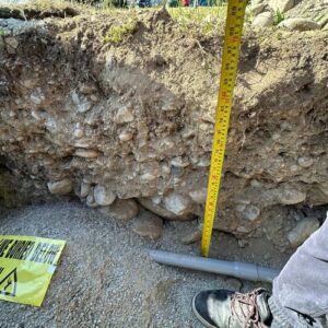 Ground-level shot of a soil profile in a freshly dug pit for EV charging installation by TCA Electric