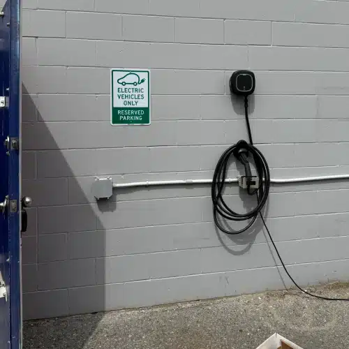 Parking area reserved for electric vehicles with wall-mounted charging station by TCA Electric