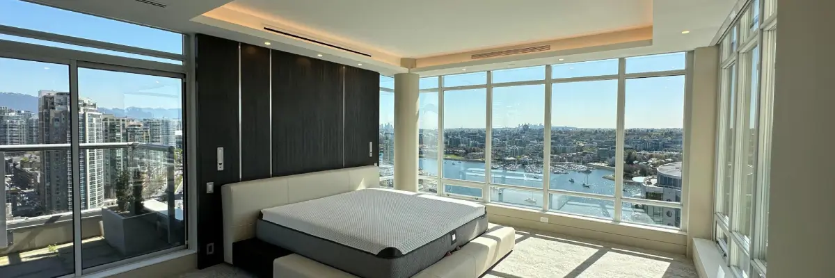 LED lighting upgrade highlighting a modern bedroom with floor-to-ceiling windows overlooking the city by TCA Electric in Canada