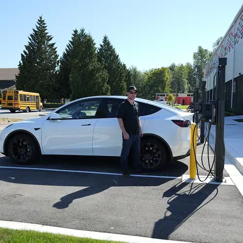 TCA Electric team member beside installed EV charger for public use in Denver