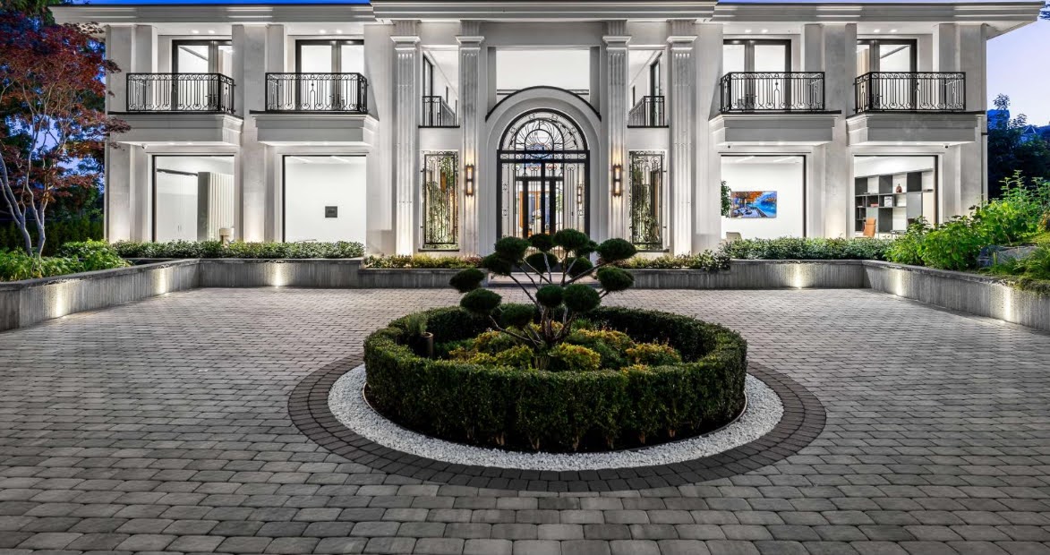 High‑end residential electrical installation West Vancouver featuring luxury two‑story house with columns, ornate balcony railings, and landscaped driveway.