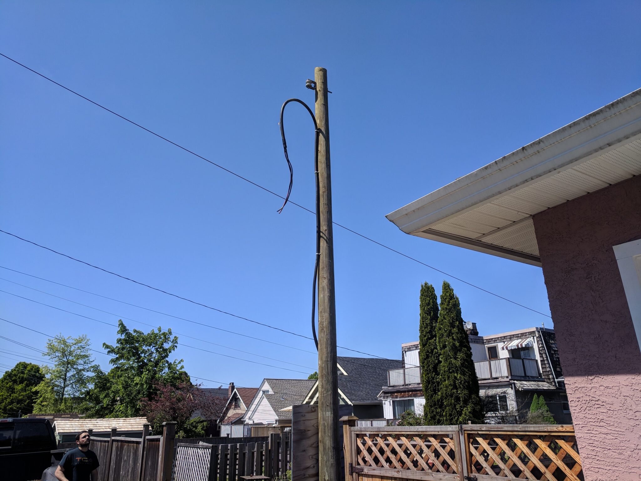 Overhead electrical service mast and drip loop on a wooden utility pole illustrating what is involved in upgrading to 200 amp service in North Vancouver by TCA Electric.