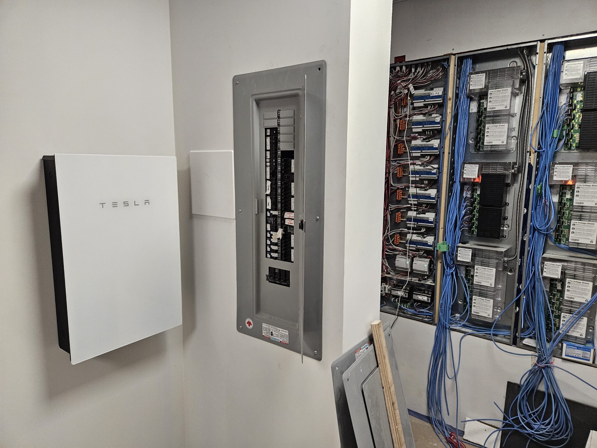 Tesla Gateway battery system unit and open electrical panel providing whole home backup power BC in North Vancouver by TCA Electric.